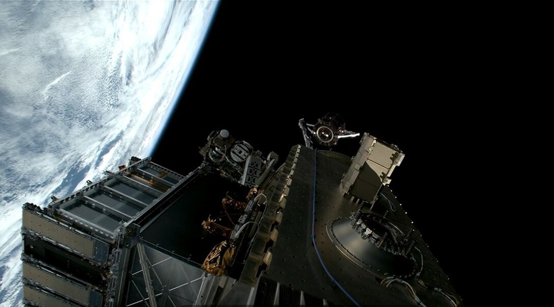 A satellite operates in dark sky near a portion of the Earth.