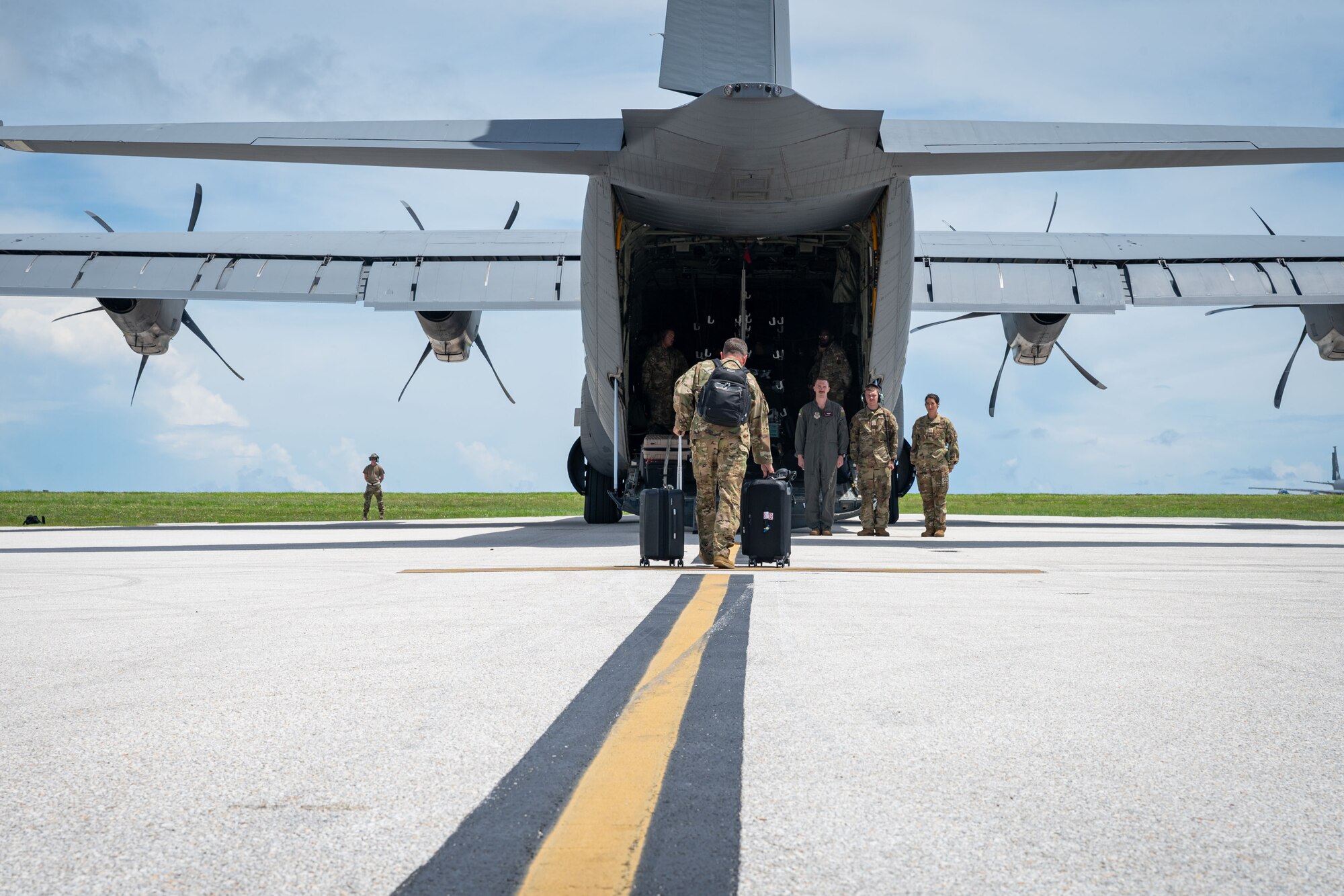 Photo of C-17 Globemaster III crewmembers preparing to greet a commander for his departure