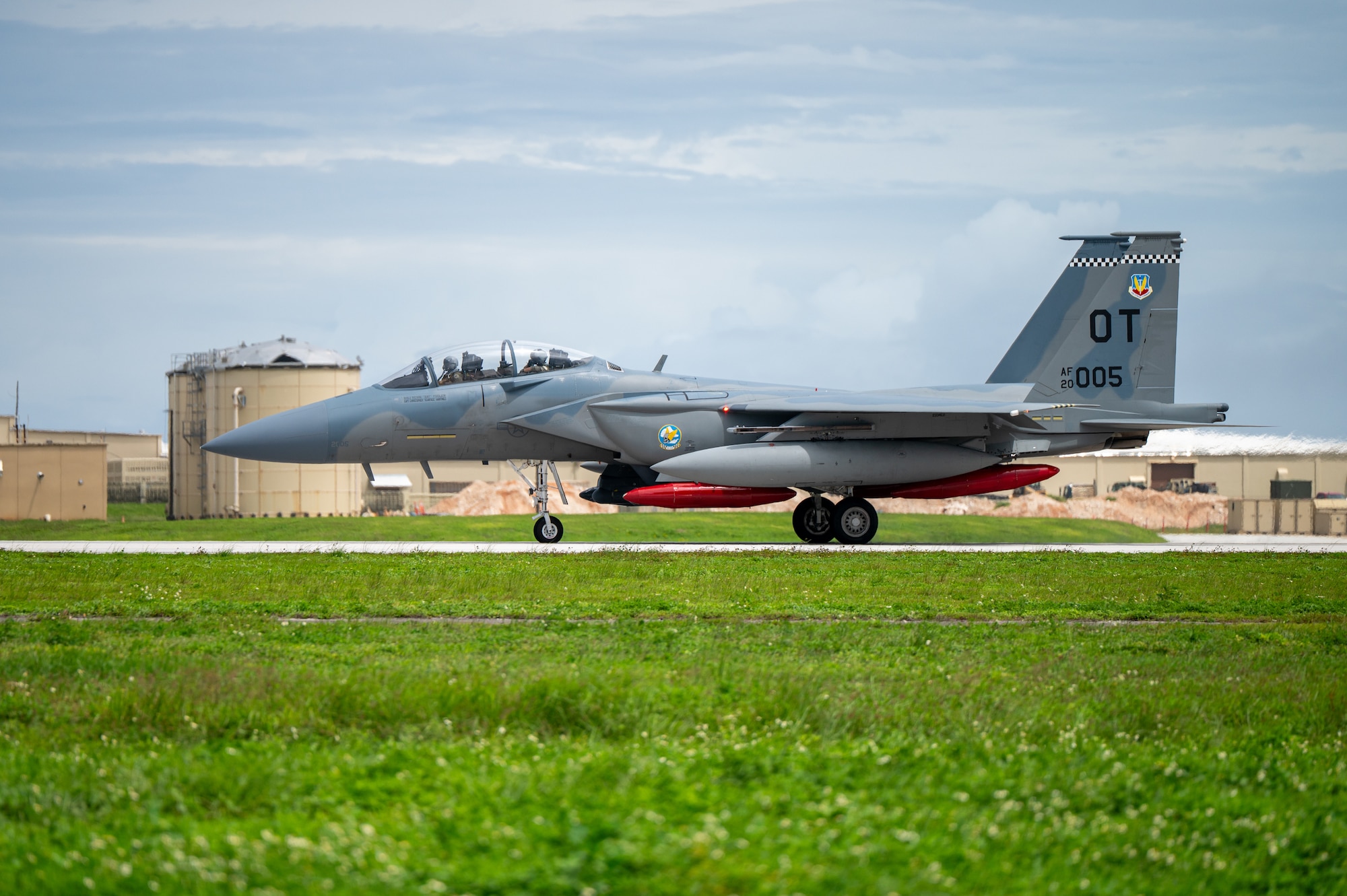 A U.S. Air Force F-15EX Eagle II lands on a runway. You can see the heat mirage behind the aircraft as it moves.