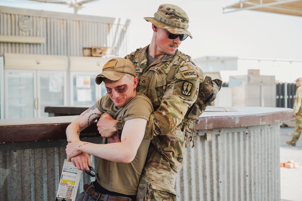 U.S. Army Pfc. Hunter Wellman, combat medic assigned to Charlie Battery 3-2 ADA, carries Staff Sgt. Chris Green, team lead with the 380th Expeditionary Security Forces Squadron, during a mass casualty exercise within the U.S. Central Command area of responsibility, June 3, 2025. This exercise included 380th Expeditionary Civil Engineering Squadron (Fire Department/Dispatch), 380th Expeditionary Medical Squadron (EMS and Clinical Teams), Army 3/116th FA Regiment – Medical Squad - Bravo Battery, Charlie Battery 3-2 ADA and the 380th Expeditionary Logistics Squadron. (U.S. Air Force photo by Staff Sgt. Mira Roman)