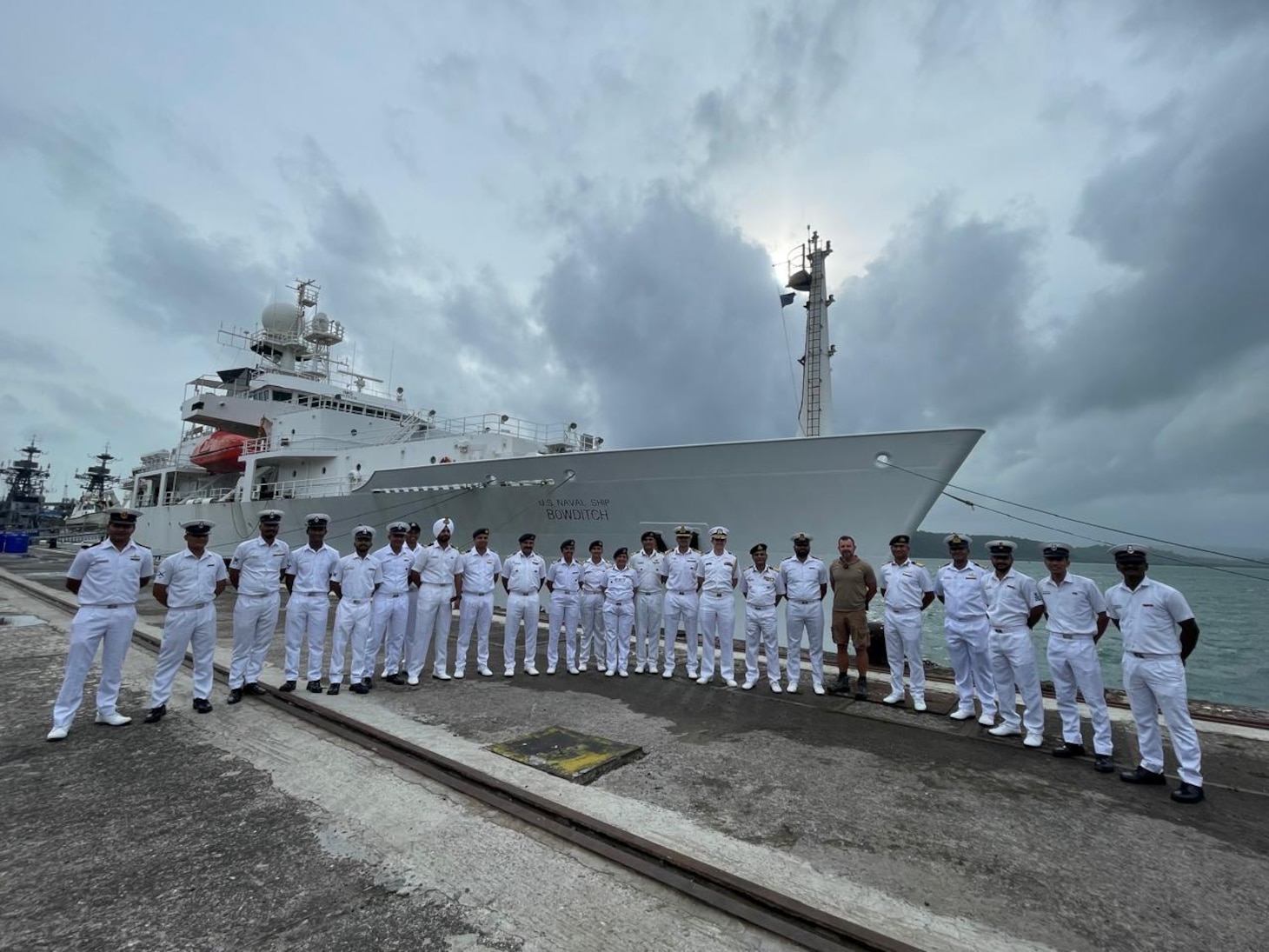 Indian Navy and Indian Coast Guard personnel alongside U.S. Navy sailors pose in front of the pathfinder class oceanographic survey ship USNS Bowditch (T-AGS 62) following a ship tour during a scheduled port visit to Sri Vijaya Puram, India, July 25, 2025.