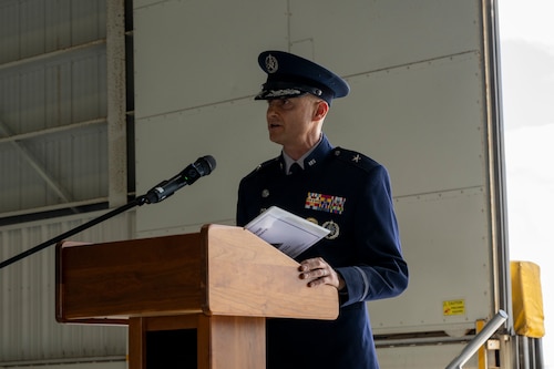 A man in uniform speaks behind a podium