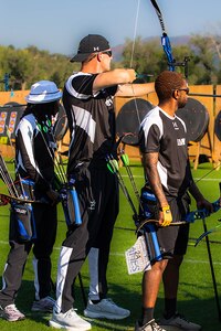 U.S. Army Staff Sgt. Coty Tuck, center, nocks an arrow in his bow and takes aim at his target during the archery event at the 2025 Department of Defense Warrior Games, Colorado Springs, Colorado, July 25, 2025.