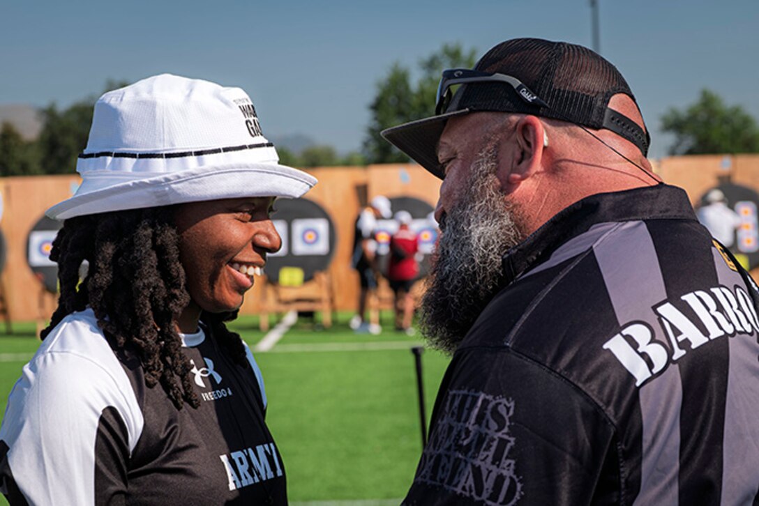 U.S. Army 1st Lt. Jani Merritt, left, talks with Team Army coach Frank Barroquiero, right, after winning her match at the archery event at the 2025 Department of Defense Warrior Games at Washburn Field in Colorado Springs, Colorado, July 25, 2025.