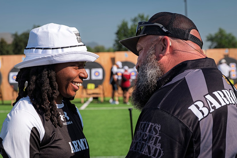 U.S. Army 1st Lt. Jani Merritt, left, talks with Team Army coach Frank Barroquiero, right, after winning her match at the archery event at the 2025 Department of Defense Warrior Games at Washburn Field in Colorado Springs, Colorado, July 25, 2025.