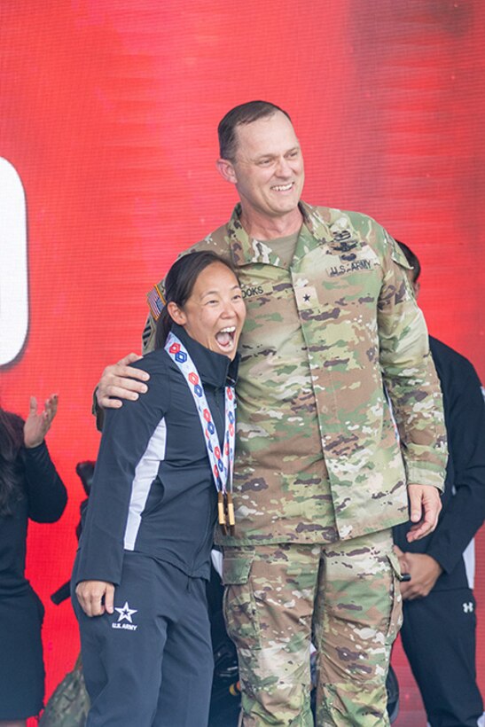 U.S. Army Capt. Kyra Maggio, left, is presented two gold medals for the cycling event by the Deputy Commanding General for Operations, U.S. Army Space and Missile Defense Command Brig. Gen. Donald K. Brooks.
