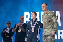 U.S. Army Sgt. Bianca Hayden, left, receives a bronze medal for the cycling event from the Deputy Commanding General for Operations, U.S. Army Space and Missile Defense Command Brig. Gen. Donald K. Brooks.