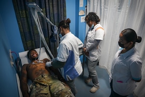 Image of Senior Airman Adrese Atkins, 931st Aerospace Medical Squadron medical administration technician, serves as a simulated patient for local nurses to test an electrocardiogram machine during AMISTAD 2025 at Academic Hospital Paramaribo, Suriname, July 17, 2025. Atkins helped the nurses relocate the EKG machine to a new treatment room before connecting it to power and calibrating it for patient use. (U.S. Air Force photo by Tech. Sgt. Elora J. McCutcheon)
