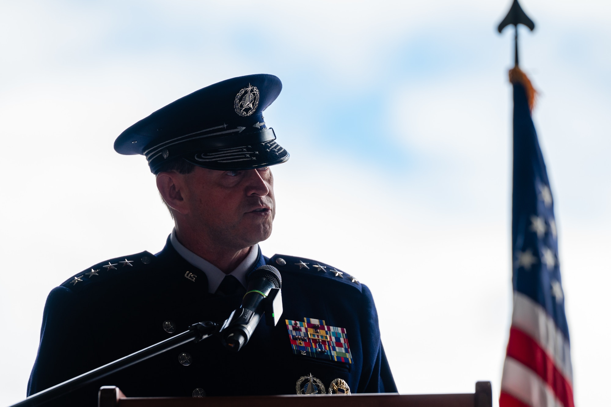 A man in uniform speaks behind a microphone