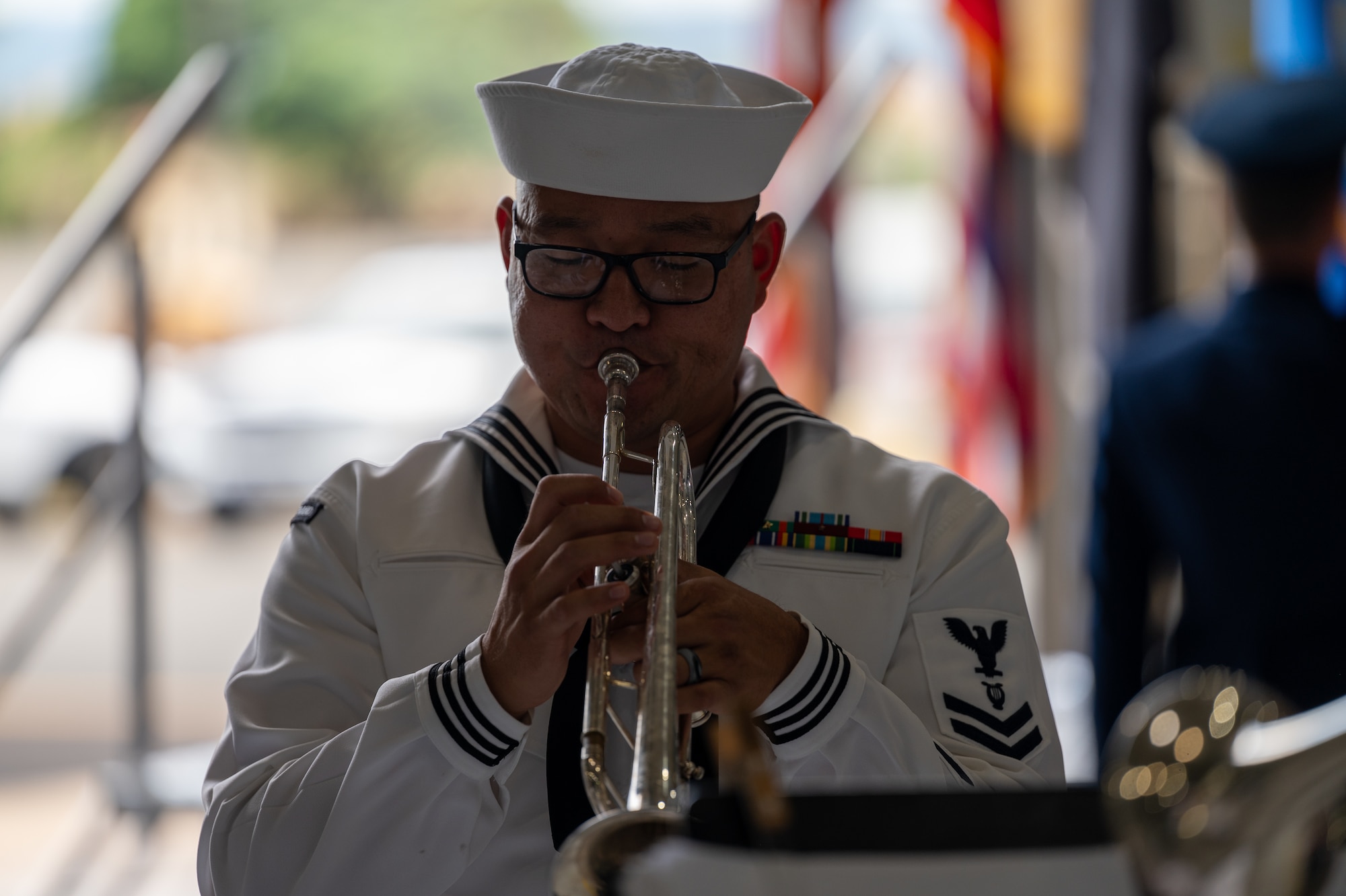 A sailor plays a trumpet