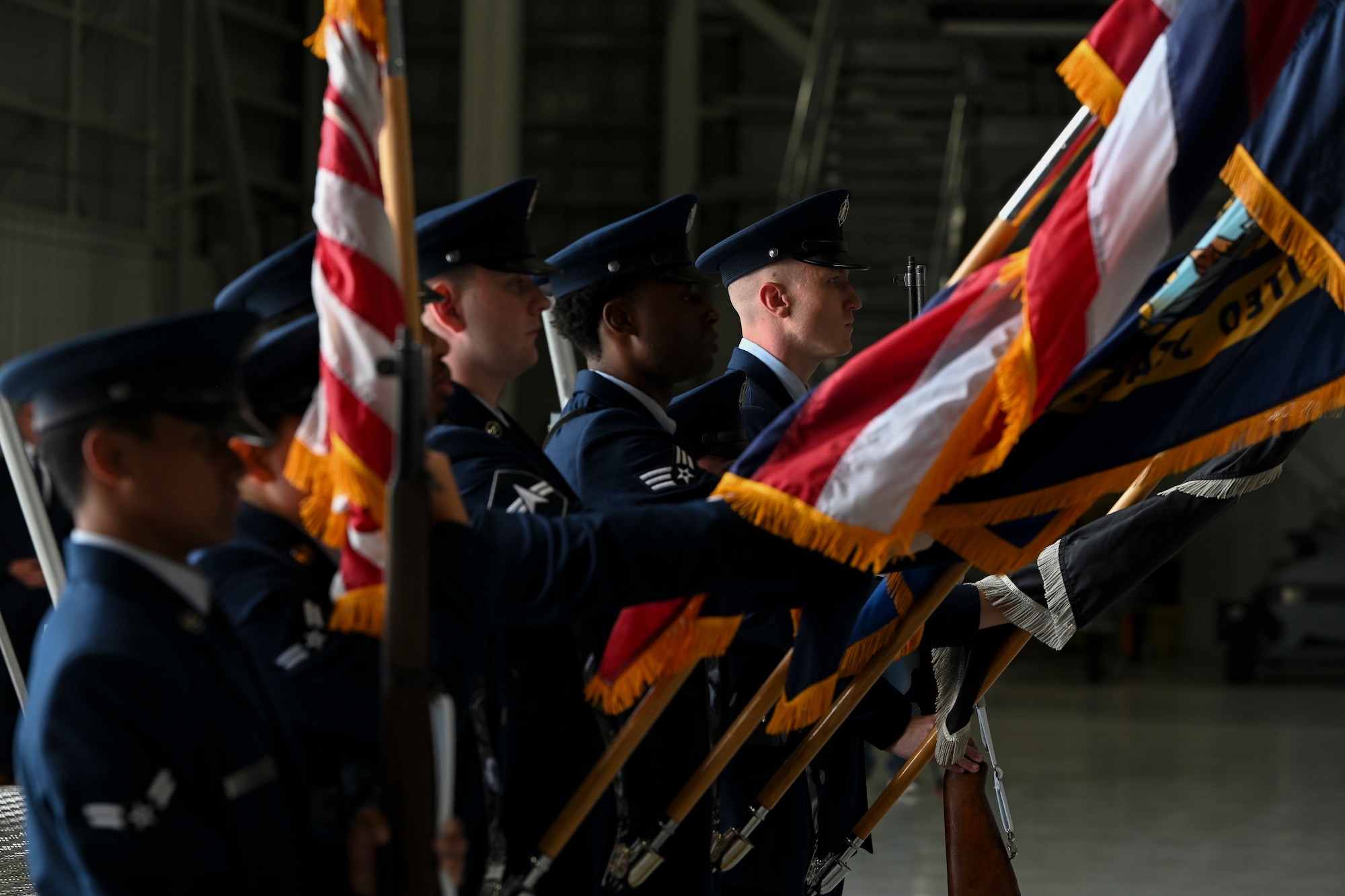A military honor guard holds flags