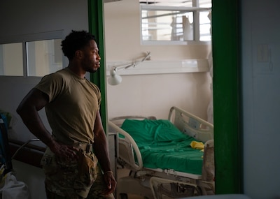 Image of Senior Airman Adrese Atkins, 931st Aerospace Medical Squadron medical administration technician, watches as local medical staff replace a hospital bed at Academic Hospital Paramaribo, Suriname, July 17, 2025. Atkins described AMISTAD 2025 as a valuable learning opportunity since he was challenged with fixing equipment while patients were actively being treated in the same room, or patching rusted gear with paint instead of being able to replace it outright. (U.S. Air Force photo by Tech. Sgt. Elora J. McCutcheon)