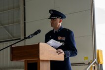 A man in uniform speaks behind a podium
