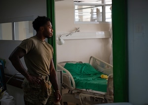 Image of Senior Airman Adrese Atkins, 931st Aerospace Medical Squadron medical administration technician, watches as local medical staff replace a hospital bed at Academic Hospital Paramaribo, Suriname, July 17, 2025. Atkins described AMISTAD 2025 as a valuable learning opportunity since he was challenged with fixing equipment while patients were actively being treated in the same room, or patching rusted gear with paint instead of being able to replace it outright. (U.S. Air Force photo by Tech. Sgt. Elora J. McCutcheon)