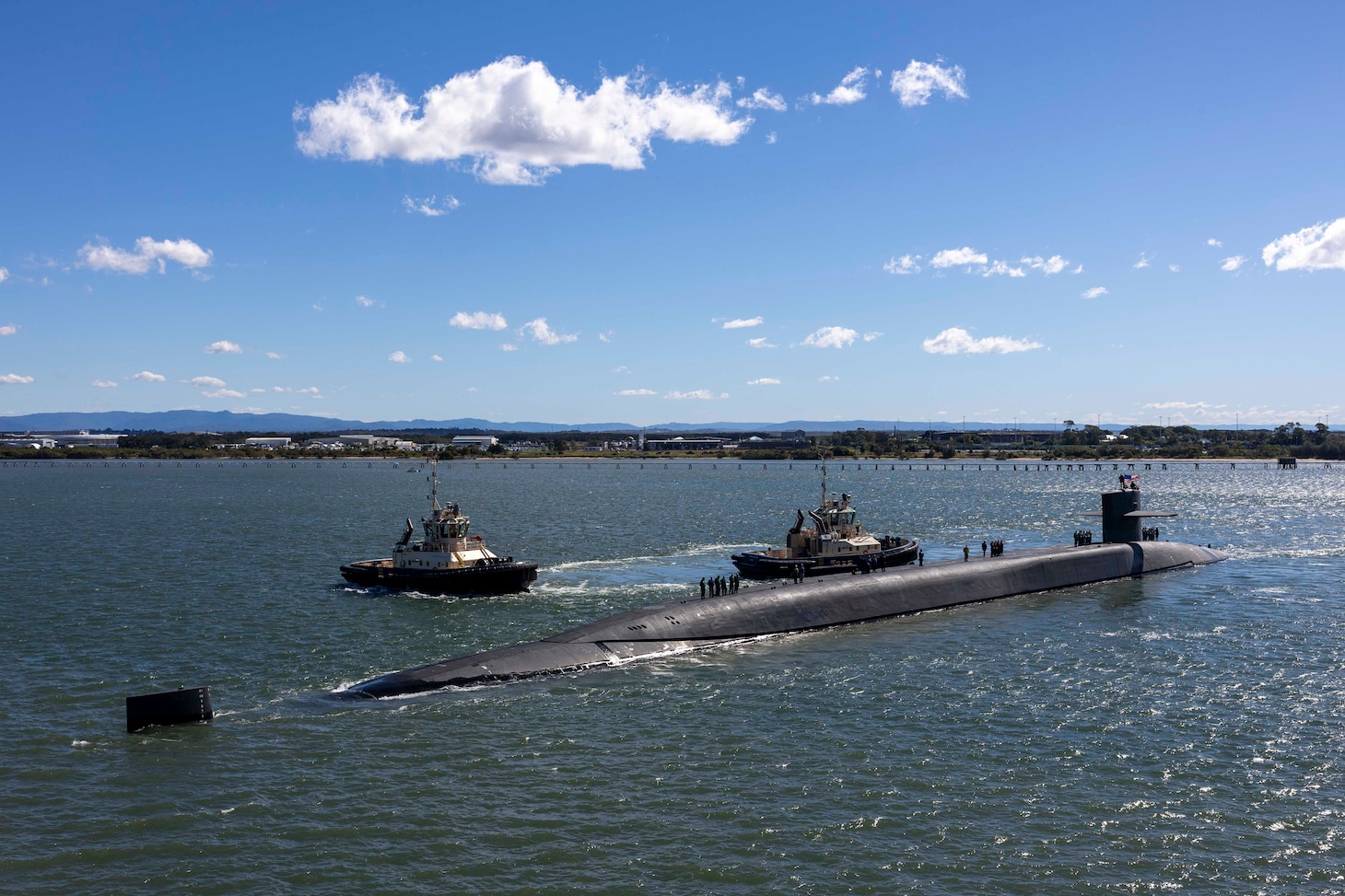 BRISBANE, Australia (July 27, 2025) – The Ohio-class guided-missile submarine USS Ohio (SSGN 726) prepares to moor alongside the forward-deployed submarine tender USS Frank Cable (AS 40) in Brisbane, Australia, for a scheduled port visit July 27, 2025. Ohio and Frank Cable are in port Brisbane, Australia, as part of routine operations in support of the U.S. 7th Fleet, the U.S. Navy’s largest forward-deployed numbered fleet, operating with allies and partners in preserving a free and open Indo-Pacific region. (U.S. Navy photo by Mass Communication Specialist 3rd Class Haley Wilson)