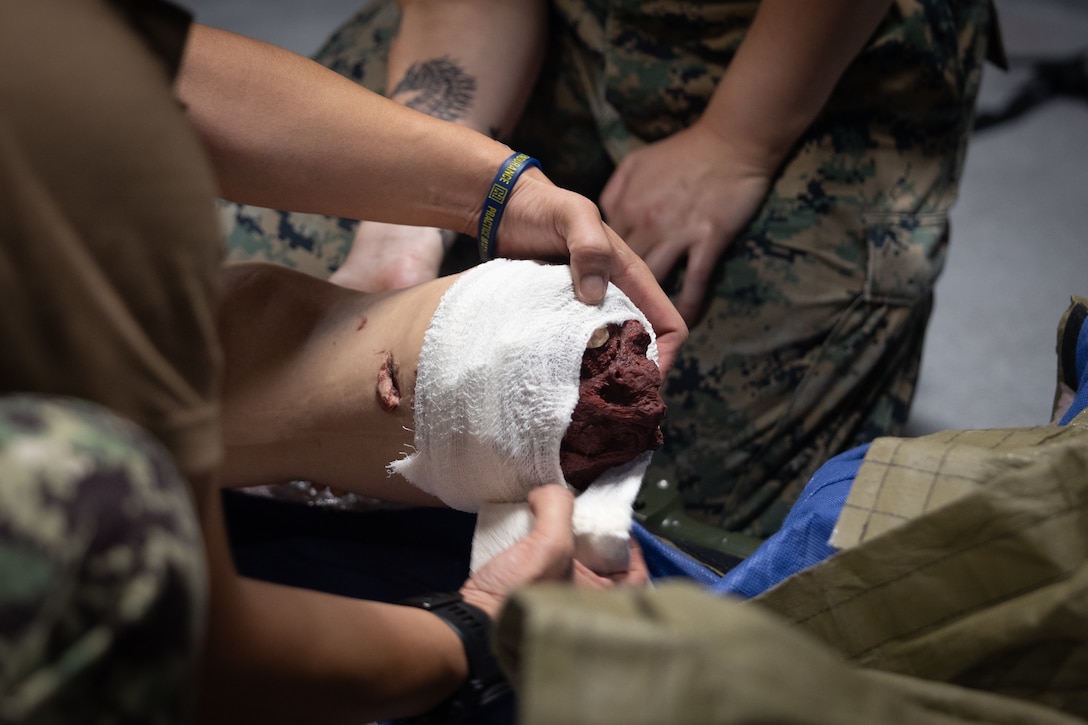 U.S. Navy Lt. Cmdr. Carolan Whitney, a medical officer with 2nd Medical Battalion, 2nd Marine Logistics Group, applies a bandage on a simulated casualty during a Tier IV Tactical Combat Casualty Care Course at the Battle Skills Training School, Marine Corps Base Camp Lejeune, North Carolina, July 21, 2025. This was the first ever Tier IV TCCC hosted by a Marine Corps command and the first course executed by U.S. Navy personnel on the East Coast. The course trains select military service members to become proficient combat paramedics capable of providing advanced casualty care at the point of injury on the battlefield and in austere environments.