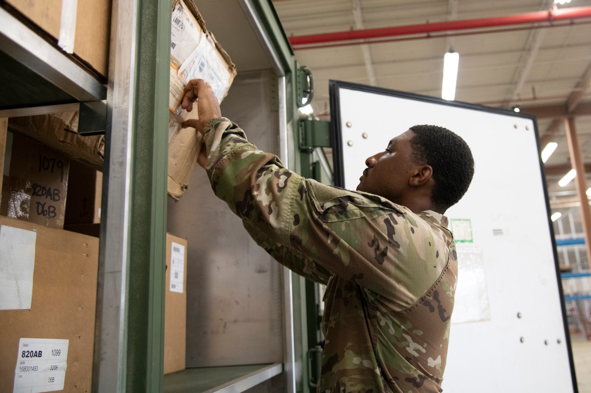 Airman removes a supply box from a storage container.