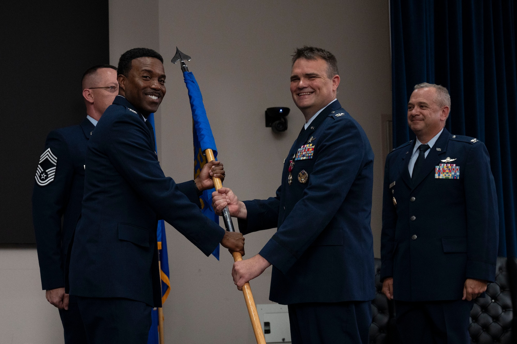 Col. Richard Wallace relinquishes command of the 960th Cyberspace Operations Group during the change of command ceremony at JBSA-Lackland, Texas on July 12, 2025. The group guidon is received by Col. Silas Darden. (US Air Force photo by TSgt Melissa Estevez)