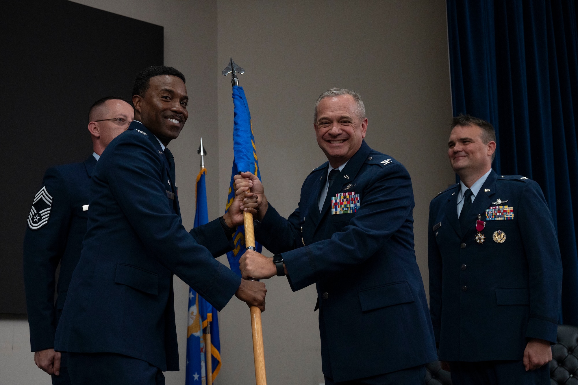 Col. Andrew Feth assumes command of the 960th Cyberspace Operations Group and receives the group guidon from Col. Silas Darden during the 960th Cyberspace Operations Group change of command ceremony at JBSA-Lackland, Texas on July 12, 2025. (US Air Force photo by TSgt Melissa Estevez)
