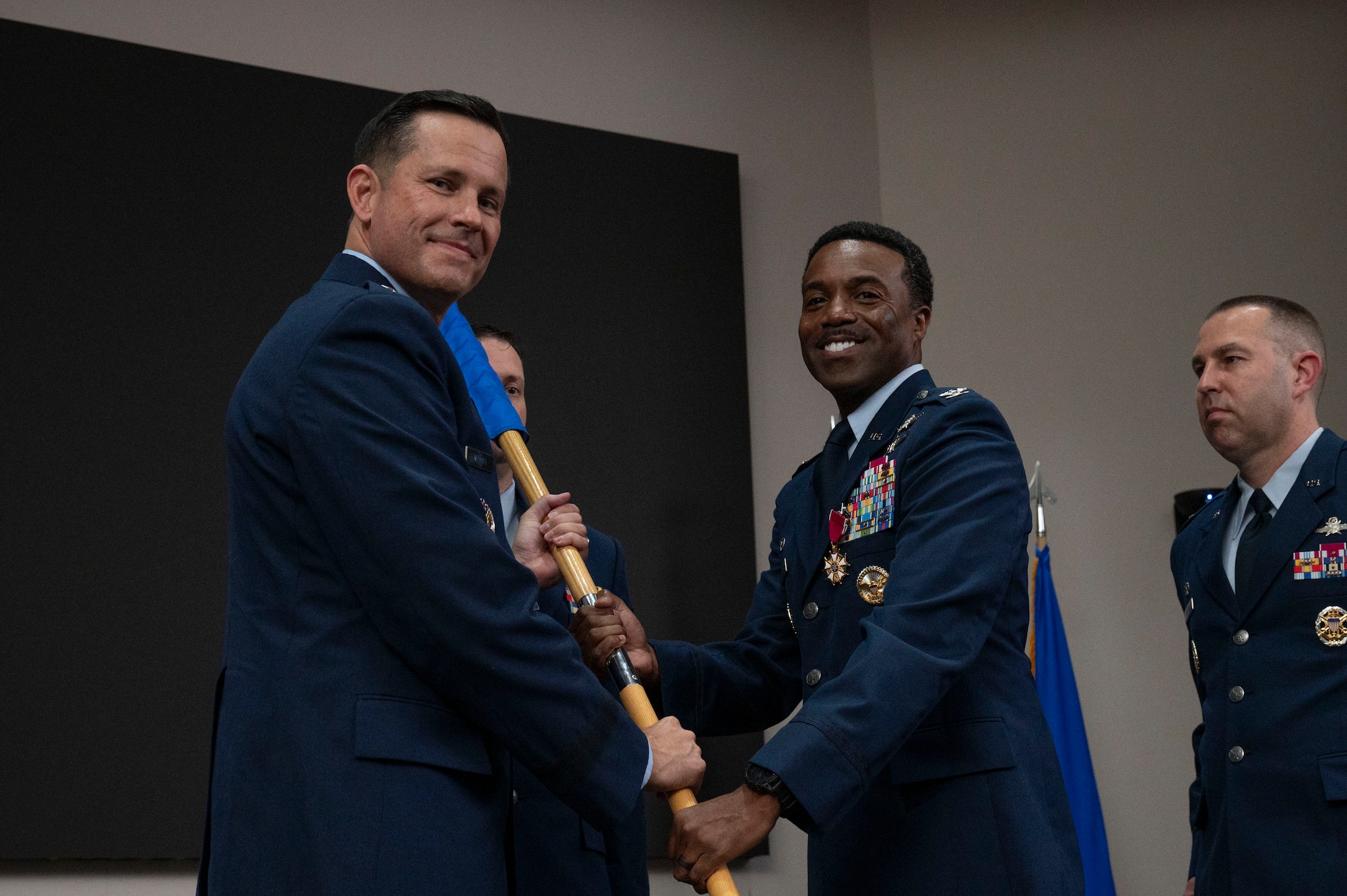 Col. Silas Darden relinquishes command of the 960th Cyberspace Wing during the change of command ceremony at JBSA-Lackland, Texas on July 12, 2025. The wing guidon is received by Brig. Gen. Kevin Merrill, 10th Air Force commander. (US Air Force photo by TSgt Melissa Estevez)