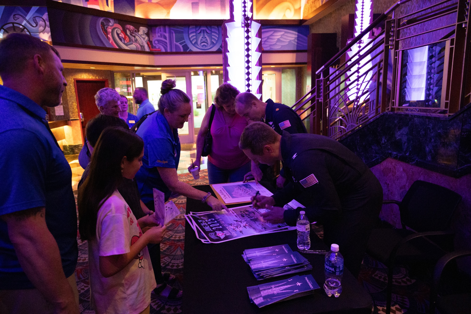 People signing movie posters.