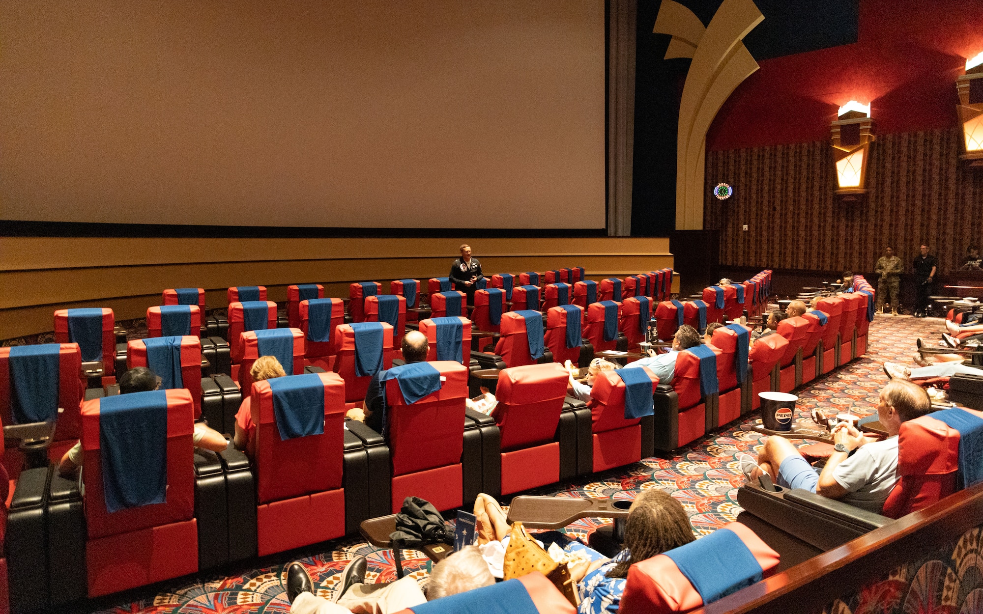 Man stands in front of movie theatre.