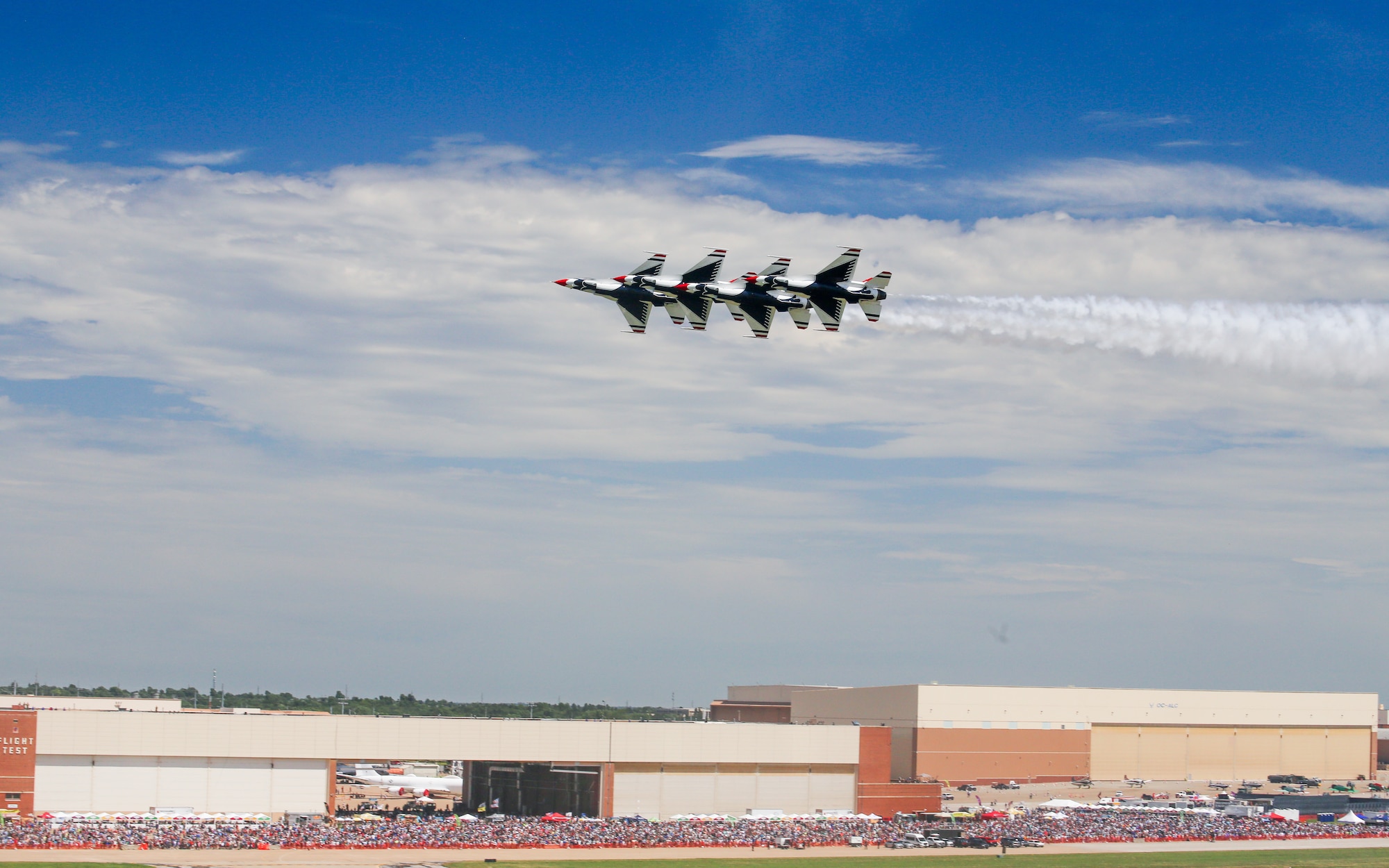 Aircraft flying over crowd.
