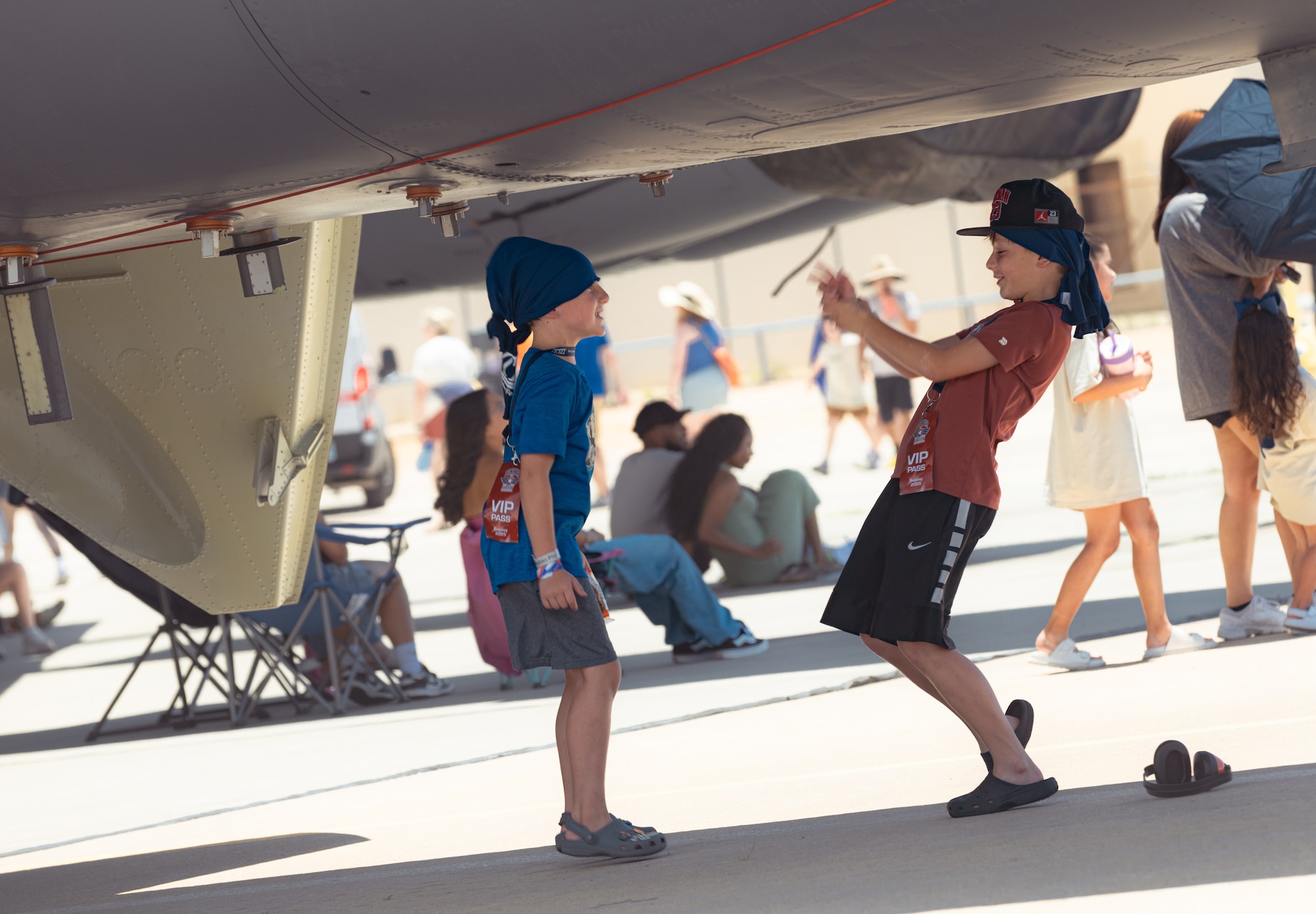 Kids playing under plane.