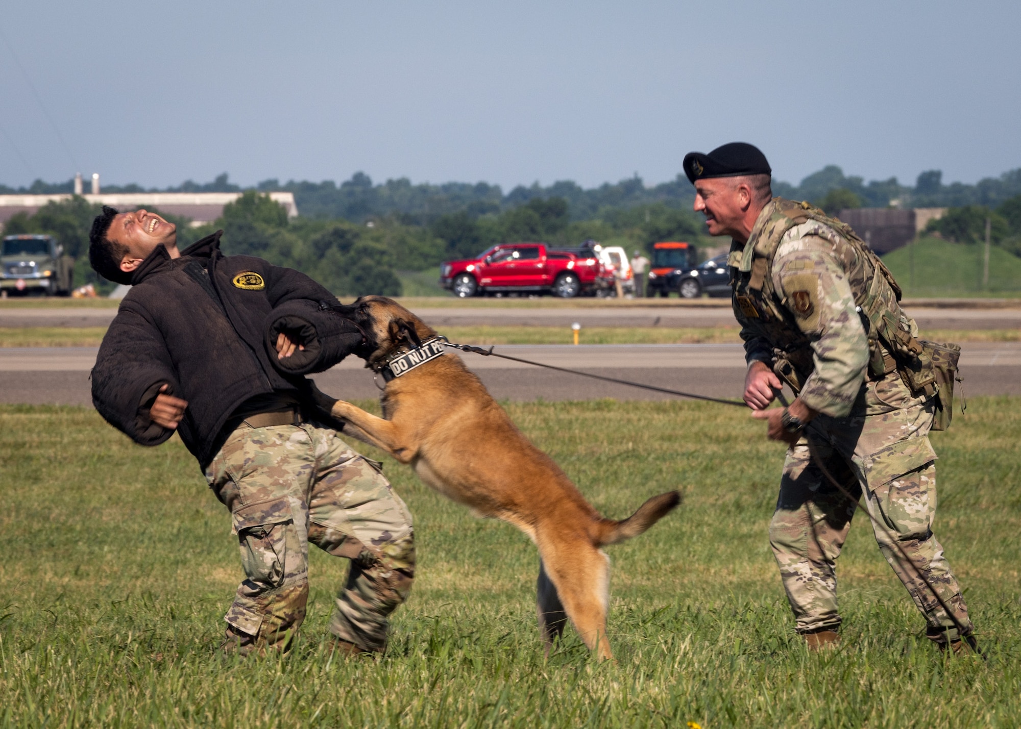 Military working dog bites man in protective suit.