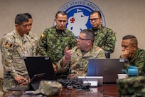 U.S. Army Chief Warrant Officer 4 Alexander Fraire, middle, senior geospatial warrant officer with the 512th Geospatial Engineering Detachment, Headquarters and Headquarters Battalion, U.S. Army South, demonstrates and explains the geospatial data capturing platform used by his unit during a combined geospatial subject matter expert exchange (SMEE) at Fort Sam Houston, Texas, July 23, 2025. The SMEE, hosted by 512th Geospatial Engineer Detachment, Headquarters and Headquarters Battalion, U.S. Army South, focused on building interoperability and partner capacity in geospatial engineering. (U.S. Army photo by Sgt. Joshua Taeckens)