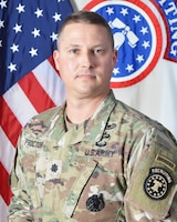 Male Soldier in front of the United States National flag and the United States Army Recruiting Command flag