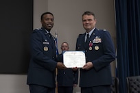 Col. Richard Wallace receives the Legion of Merit during the 960th Cyberspace Operations Group change of command ceremony at JBSA-Lackland, Texas on July 12, 2025. The ceremony was held prior to the 960th Cyberspace Wing change of command. Col. Wallace and Col. Silas Darden present the certificate for a photo. (US Air Force photo by TSgt Melissa Estevez)