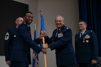 Col. Andrew Feth assumes command of the 960th Cyberspace Operations Group and receives the group guidon from Col. Silas Darden during the 960th Cyberspace Operations Group change of command ceremony at JBSA-Lackland, Texas on July 12, 2025. (US Air Force photo by TSgt Melissa Estevez)