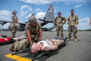 An airman conducts patient assessment of a simulated casualty of a mass casualty exercise.