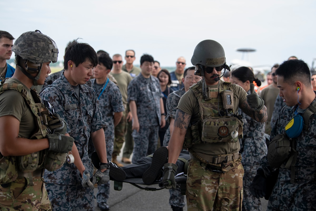 Airmen demonstrate how to carry a litter patient onto a C-130J Super Hercules.