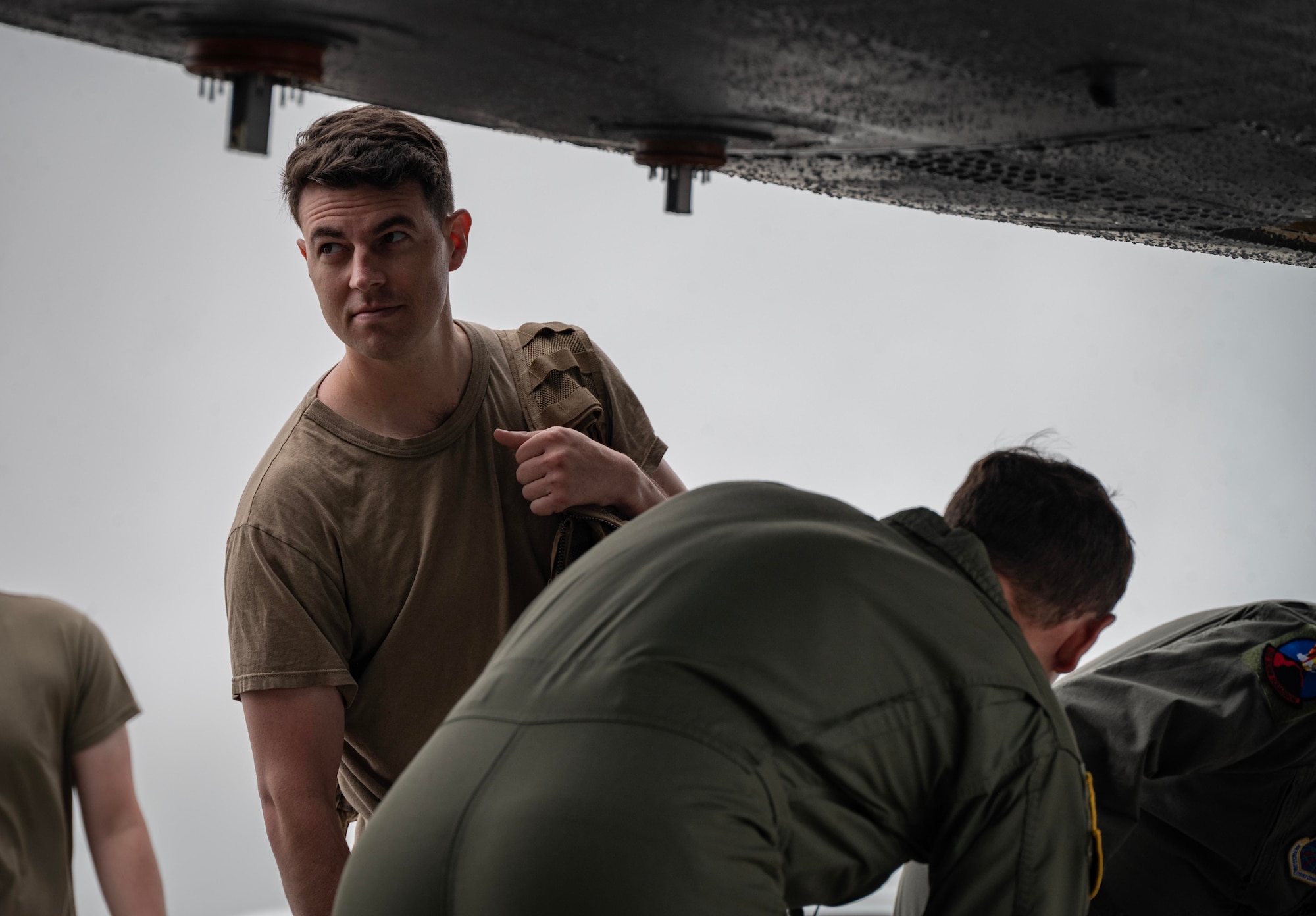 U.S. Air Force Senior Airman Aaron Cusick, center, 23rd Expeditionary Bomb Squadron aircrew flight equipment shift lead, collects aircrew flight equipment from USAF B-52H Stratofortress aircrew after landing from a Bomber Task Force mission at Andersen Air Force Base, Guam, July 23, 2025. Our bomber force, always ready to respond, is a powerful example of how the USAF deters threats and enhances security for ourselves, our partners, and our allies around the world. (U.S. Air Force photo by Senior Airman Alyssa Bankston)