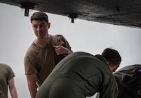 U.S. Air Force Senior Airman Aaron Cusick, center, 23rd Expeditionary Bomb Squadron aircrew flight equipment shift lead, collects aircrew flight equipment from USAF B-52H Stratofortress aircrew after landing from a Bomber Task Force mission at Andersen Air Force Base, Guam, July 23, 2025. Our bomber force, always ready to respond, is a powerful example of how the USAF deters threats and enhances security for ourselves, our partners, and our allies around the world. (U.S. Air Force photo by Senior Airman Alyssa Bankston)
