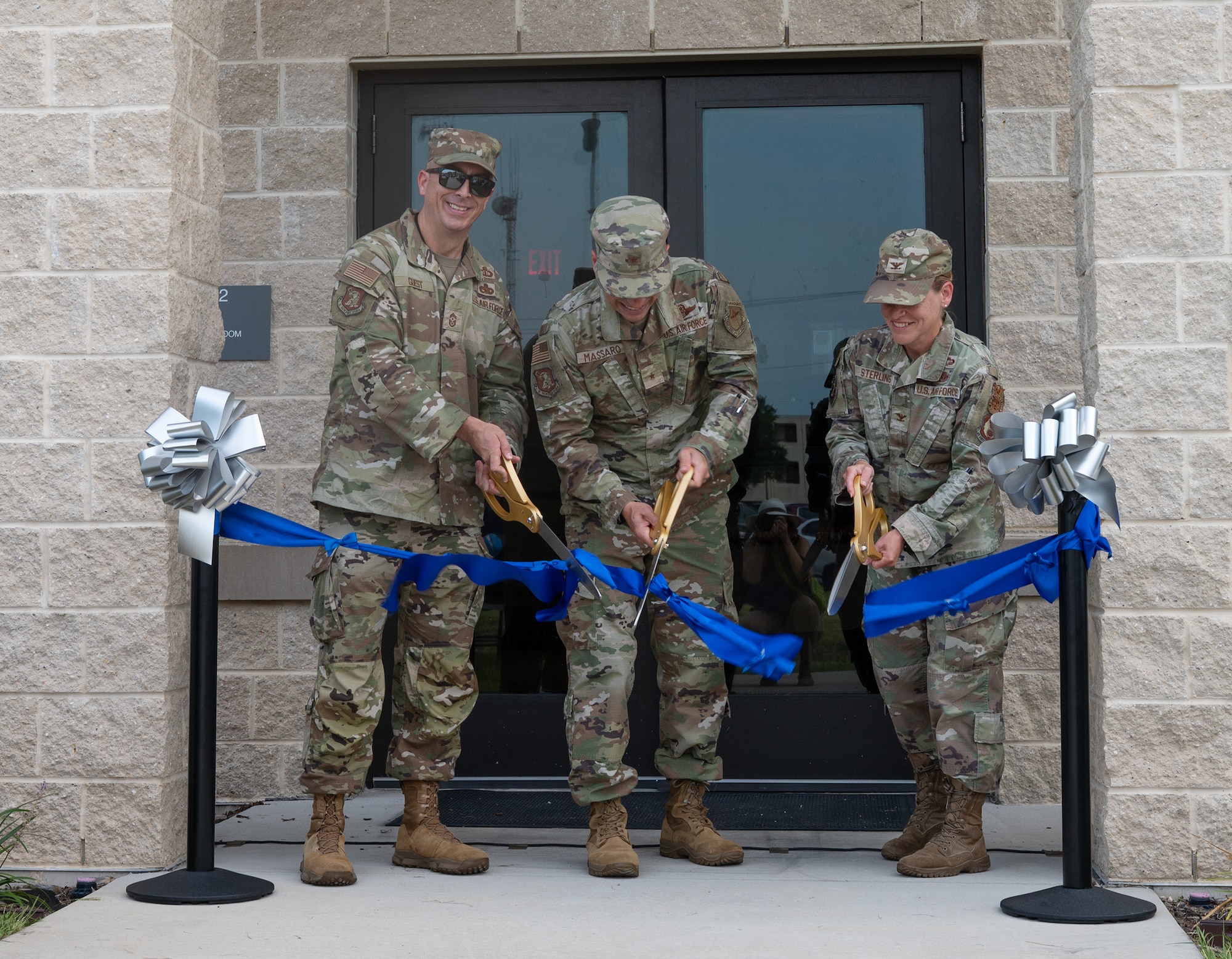 Senior leadership cut ribbon in front of new dorm facility.