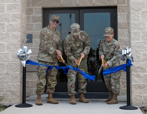 Senior leadership cut ribbon in front of new dorm facility.