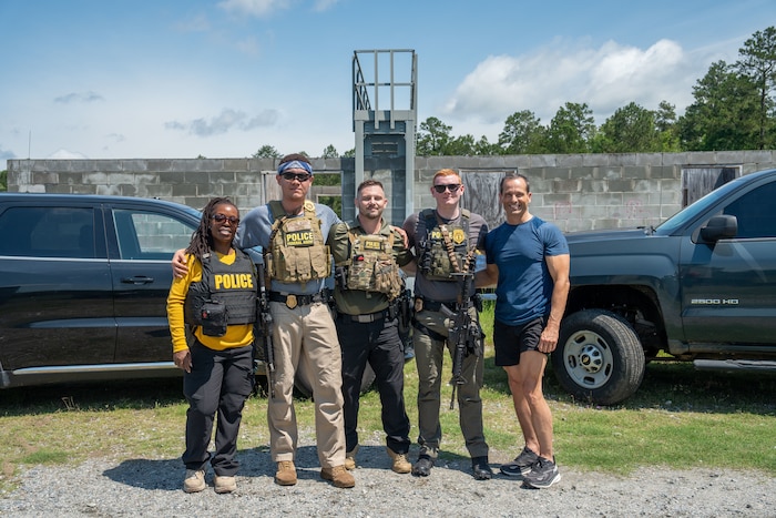 A full body photo of a group of people posing for a photo