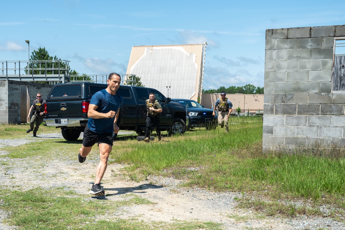 Man runs during a fugitive capture exercise with special agents behind him