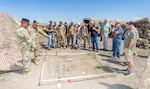 Lt. Col. Christopher Miller, commander of the 3rd Battalion, 116th Cavalry Regiment, and Staff Sgt. Stephen Young of Charlie Company demonstrates a terrain table used by the mechanized infantry company for planning training operations to civilian employers during an Employer Support of the Guard and Reserve Boss Lift event on July 27, 2025, at the Orchard Combat Training Center, Idaho.