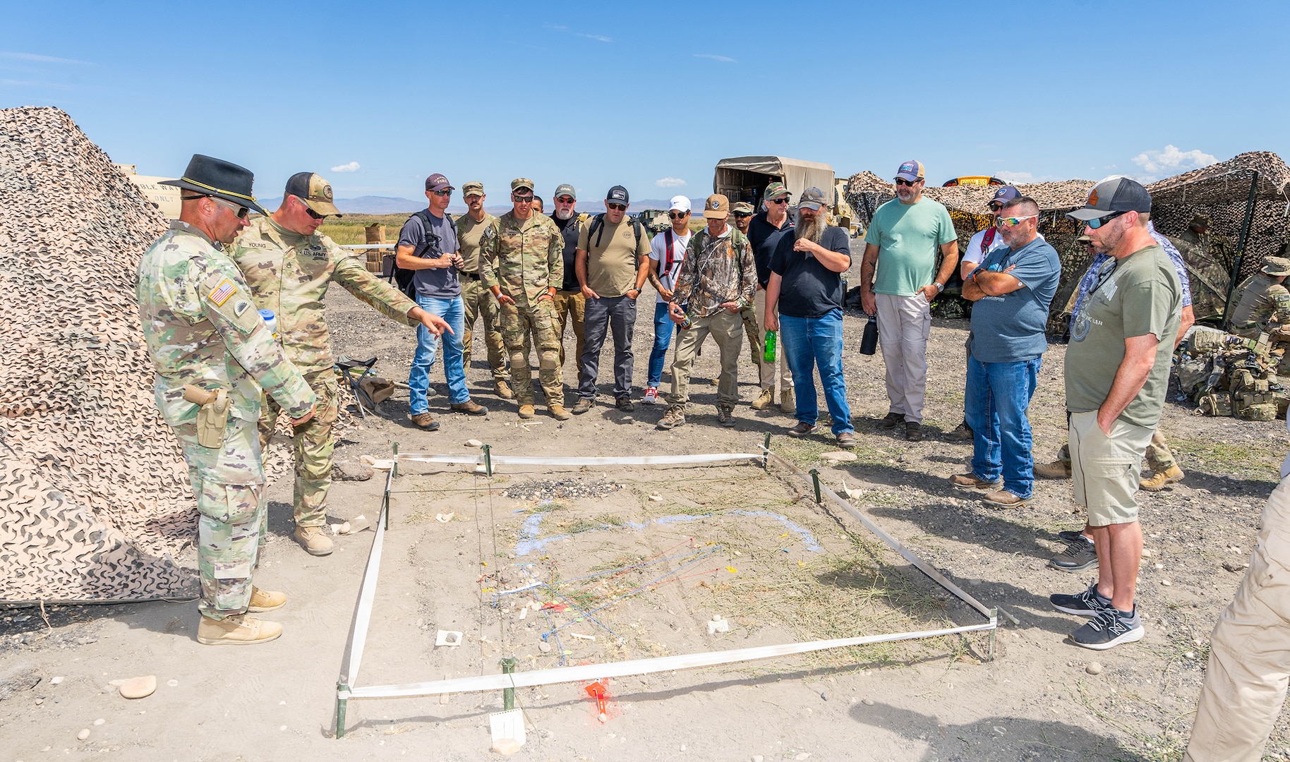 Lt. Col. Christopher Miller, commander of the 3rd Battalion, 116th Cavalry Regiment, and Staff Sgt. Stephen Young of Charlie Company demonstrates a terrain table used by the mechanized infantry company for planning training operations to civilian employers during an Employer Support of the Guard and Reserve Boss Lift event on July 27, 2025