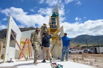 Image of Operational Contract Support (OCS) assisting a soldier setup a building.