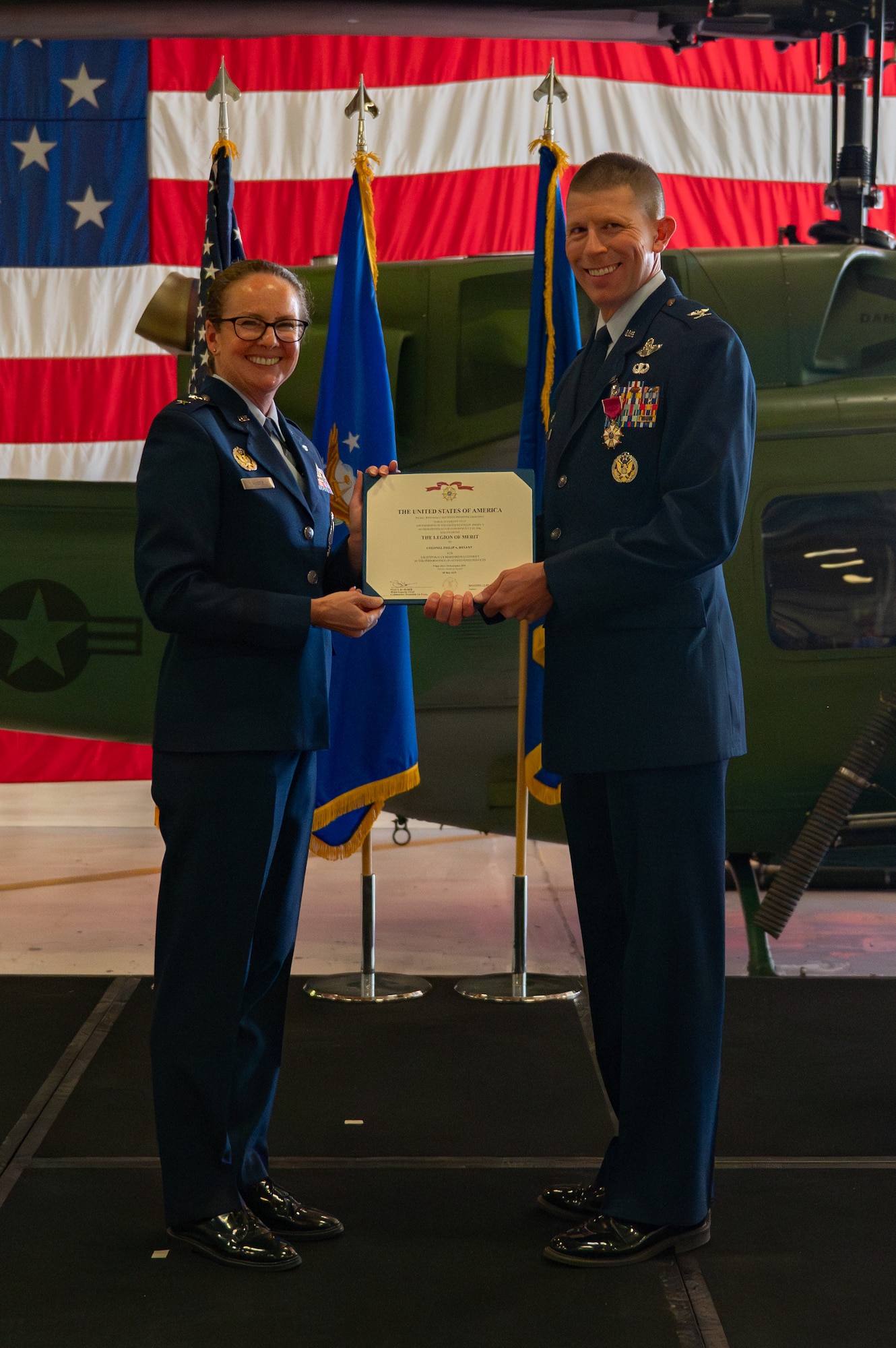 Col. Philip Bryant (right), outgoing 582nd Helicopter Group commander, is presented a medal by Maj. Gen. Stacy Huser (left), 20th Air Force commander and presiding officer, during the 582 HG change of command ceremony at F.E. Warren Air Force Base, Wyoming, July 15, 2025. The change of command ceremony reflects the orderly transition of authority within military ranks, reinforcing continuity and trust in leadership. (U.S. Air Force photo by Airman Nicholas Rowe)