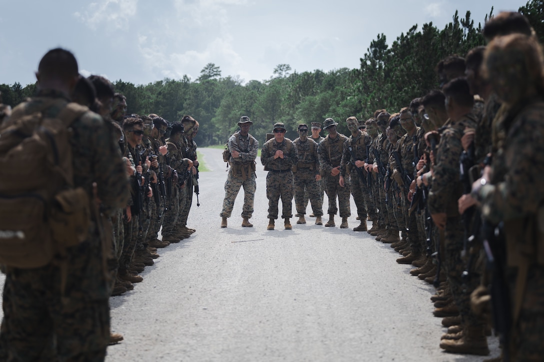 U.S. Marine Corps Gunnery Sgt. Leonardo Gonzalez, center, an assistant officer instructor with Texas A&M University, briefs U.S. Navy Reserve Officers’ Training Corps (ROTC) Midshipmen before a patrol during Fleet Marine Force East (FMF-E) at Marine Corps Base Camp Lejeune, North Carolina, July 17, 2025.  2nd Battalion, 2nd Marine Regiment provided coordination and safety support during FMF-E, a training event with the purpose of familiarizing NROTC Midshipmen who have committed to becoming Marine Corps officers with the primary communities they may serve in. (U.S. Marine Corps photo by Sgt. Jorge Borjas)