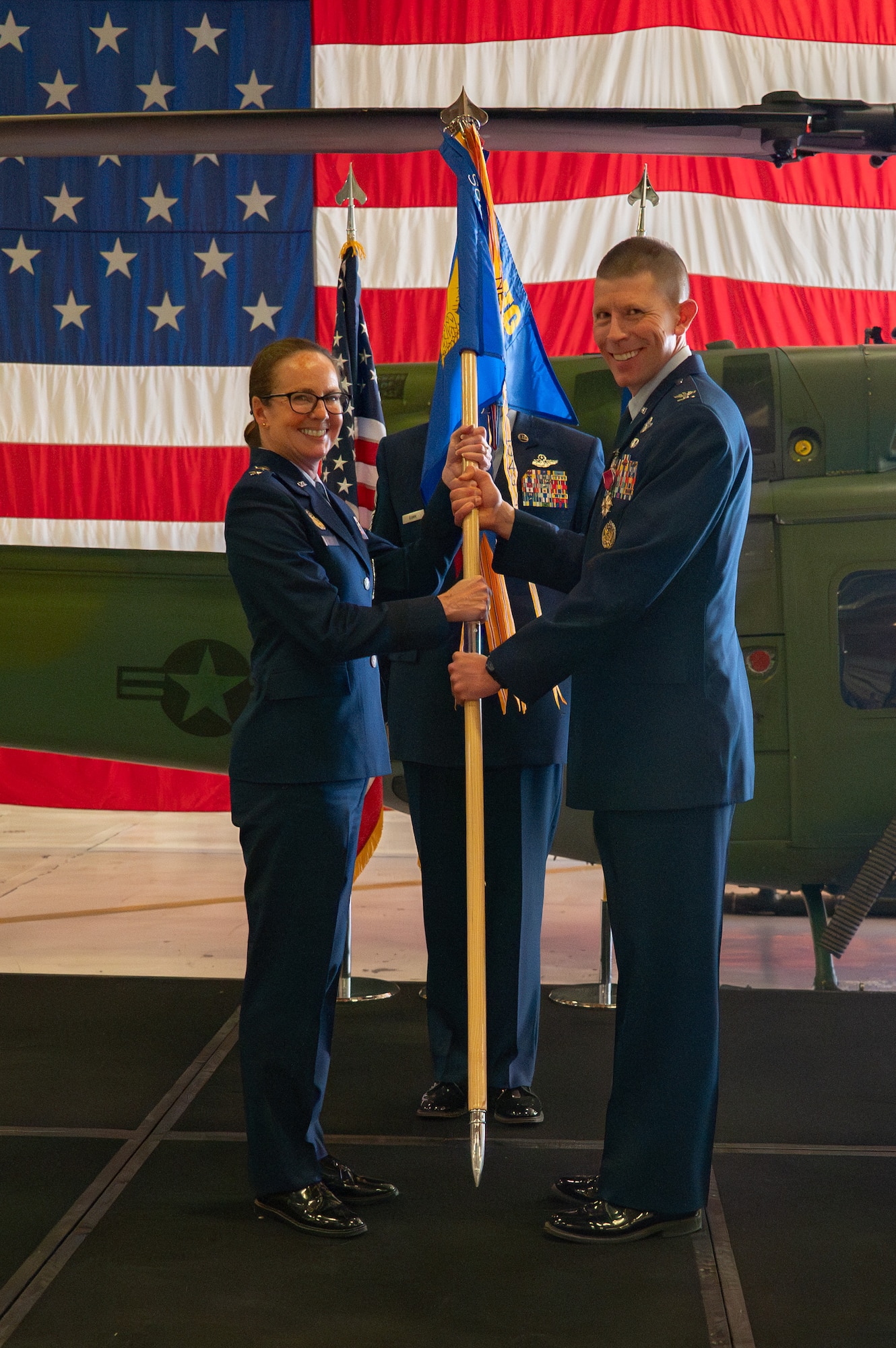 Col. Philip Bryant (right), 582nd Helicopter Group outgoing commander, passes the guidon to Maj. Gen. Stacy Huser (left), 20th Air Force commander and presiding officer, symbolizing his relinquishment of command during the 582 HG change of command ceremony at F.E. Warren Air Force Base, Wyoming, July 15, 2025. The change of command ceremony reflects the orderly transition of authority within military ranks, reinforcing continuity and trust in leadership. (U.S. Air Force photo by Airman Nicholas Rowe)