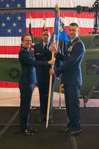 Col. Bryant Bevan (right), incoming 582nd Helicopter Group commander, accepts the guidon from Maj. Gen. Stacy Huser (right), 20th Air Force commander and presiding officer, thus assuming the role as the new commander of the 582 HG during the 582 HG change of command ceremony at F.E. Warren Air Force Base, Wyoming, July 15, 2025. The change of command ceremony reflects the orderly transition of authority within military ranks, reinforcing continuity and trust in leadership. (U.S. Air Force photo by Airman Nicholas Rowe)