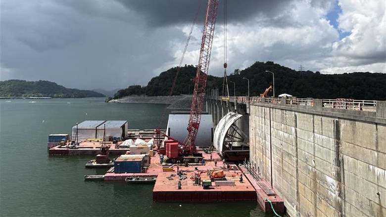 Work crews successfully remove the first massive spillway gate from Center Hill Dam July 26, 2025, on the Caney Fork River in Lancaster, Tennessee. The U.S. Army Corps of Engineers Nashville District and its contractor, American Bridge Company, hoisted the 37-feet high by 50-feet wide gate and placed it on a work barge on Center Hill Lake. This action signals the modernization of the dam's infrastructure, replacing all eight original tainter gates and lifting equipment that have been in continuous operation since 1948. (USACE Photo by Mike Freeman)