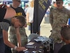 Staff Sgt. Devon Nagy with the Army Reserve (left) and 1st Lt. Jeremy Lee talk with to potential leads at the York State Fair.